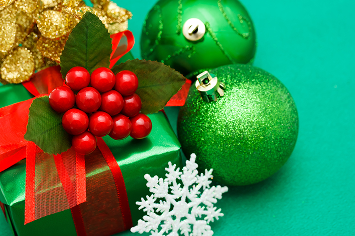 Christmas green gift box with ornaments on green background